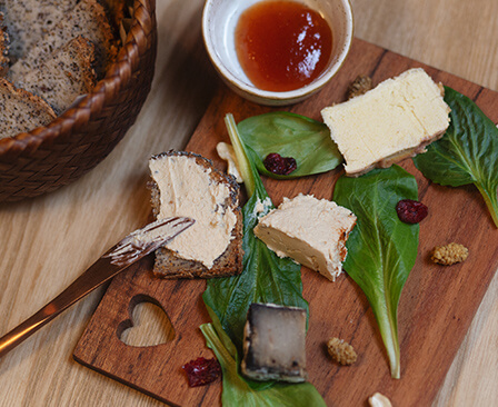 Planches de fromages végétaux avec du pain, de la sauce et des crudités